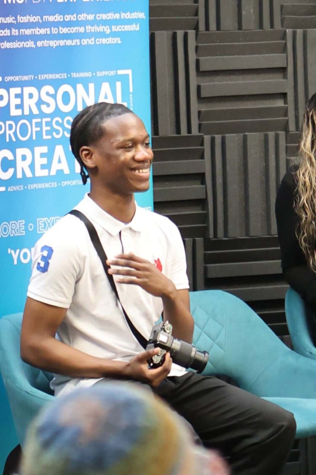 Candid laugh at a creative industry panel, camera in hand